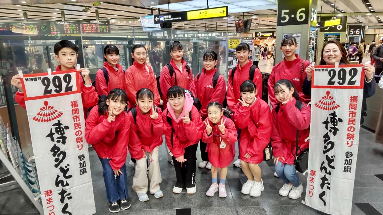 大阪駅でどんたく参加旗を持って集合写真