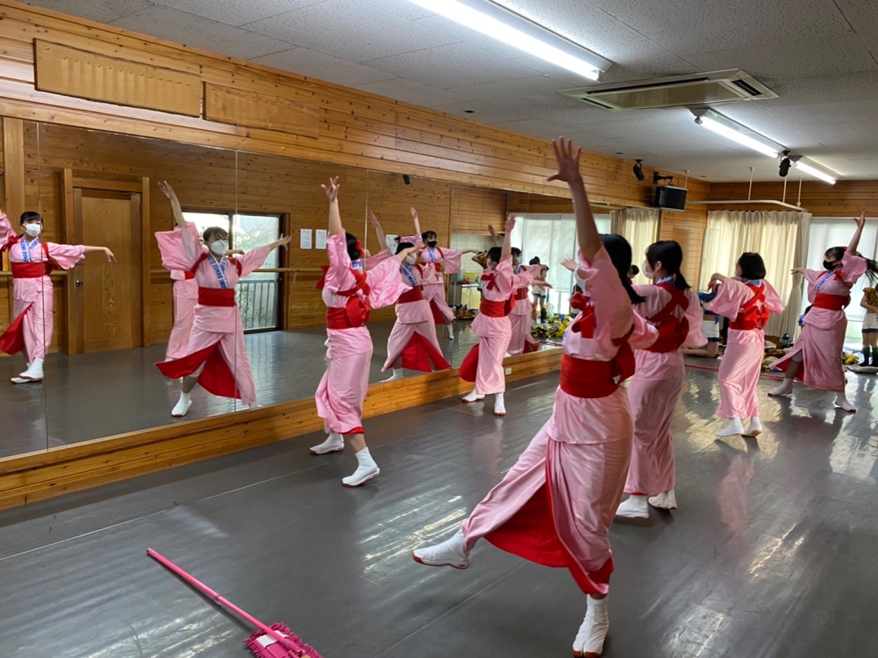 ピンクの着物に赤の帯をして、大きく手を広げ踊っています