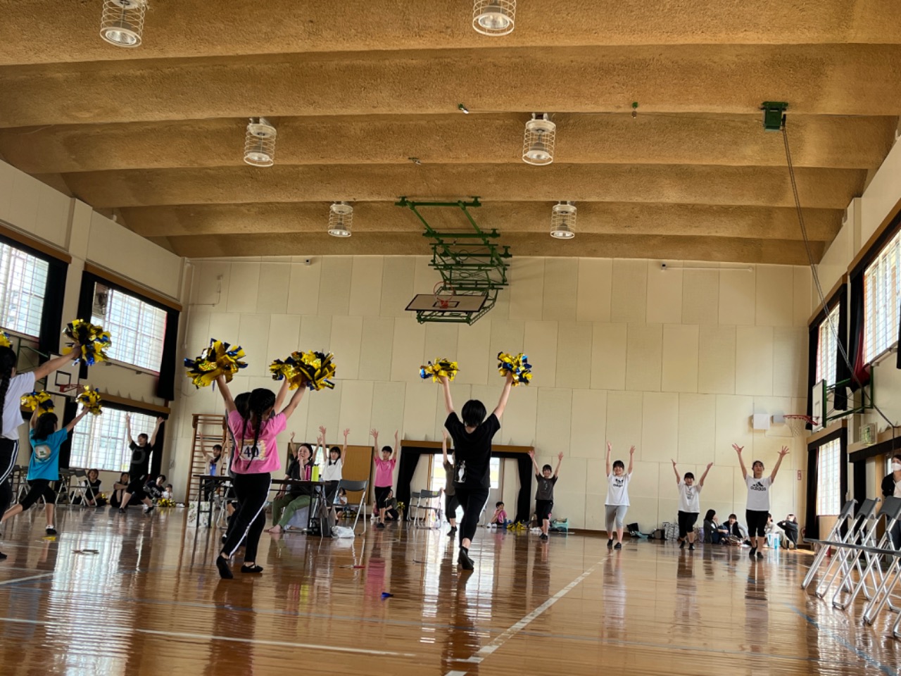 体育館で向かい合って両手を上に高く上げています