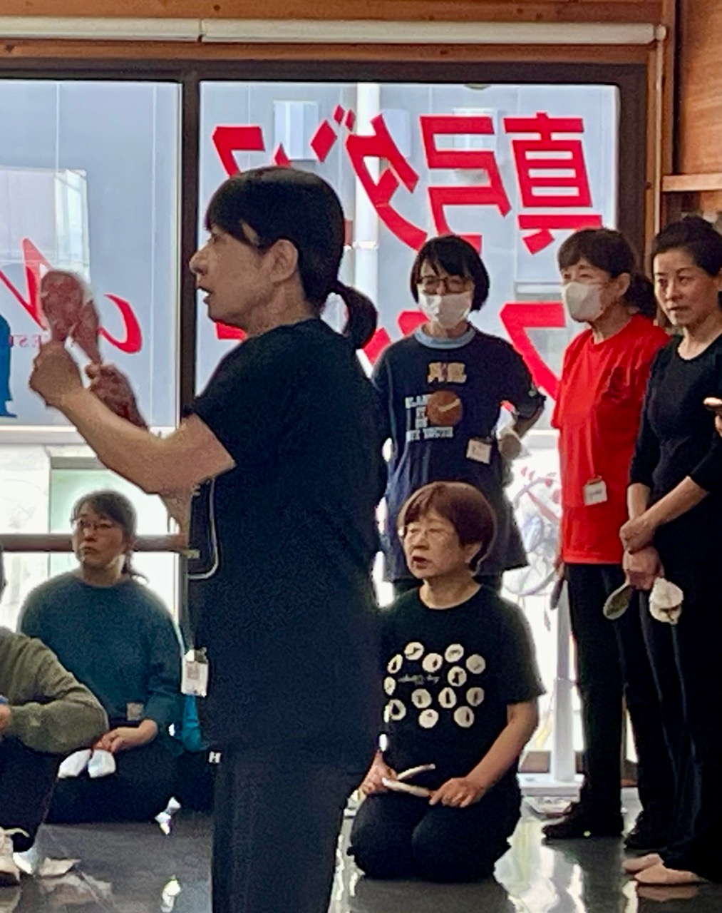 リーダーの周りに集まってメンバーたちが真剣な表情で指導を聞いている