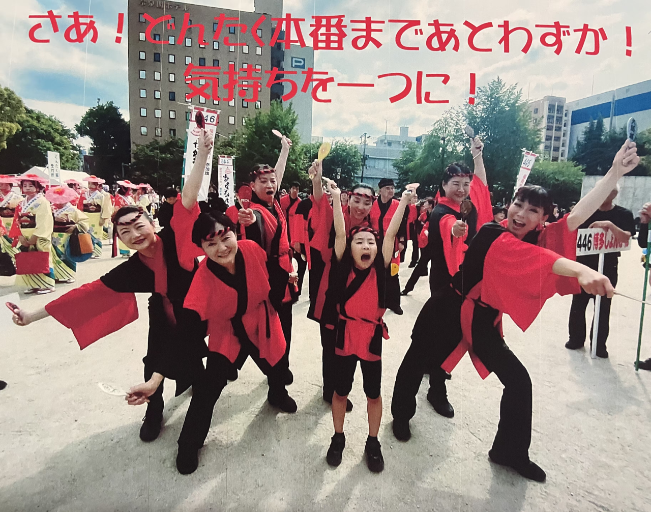 衣装をつけたメンバーが両手を広げて気合をいれている写真
