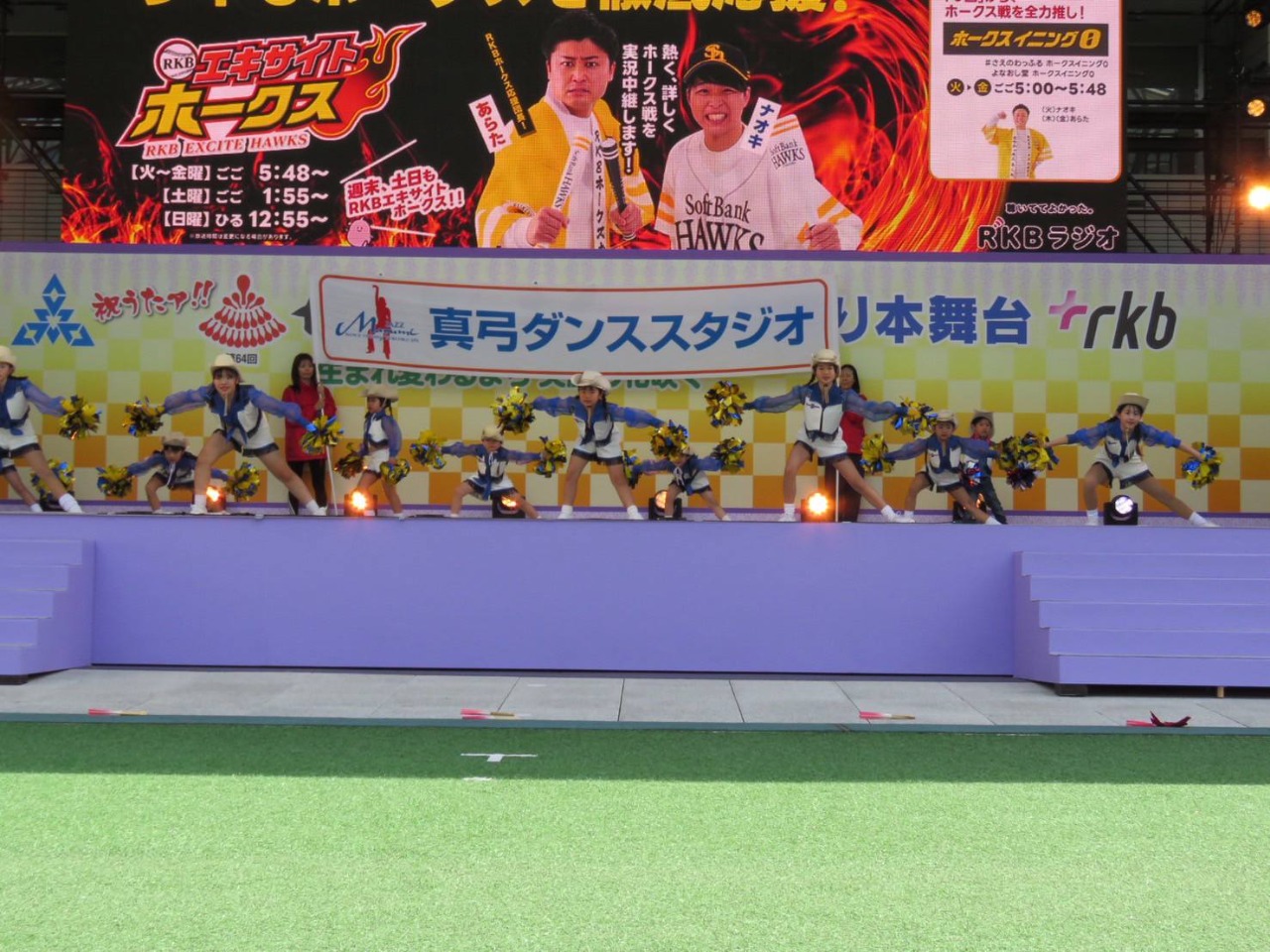 舞台の上でポンポン持ったウエスタンハットのこともだちが両手を大きく広げポーズ