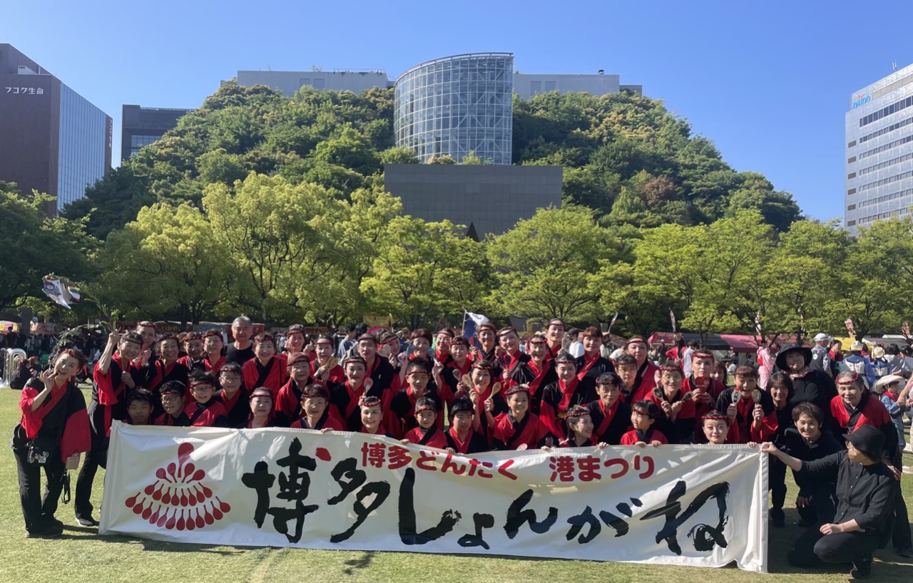 天神中央公園でアクロスと青空をバックに全員の集合写真